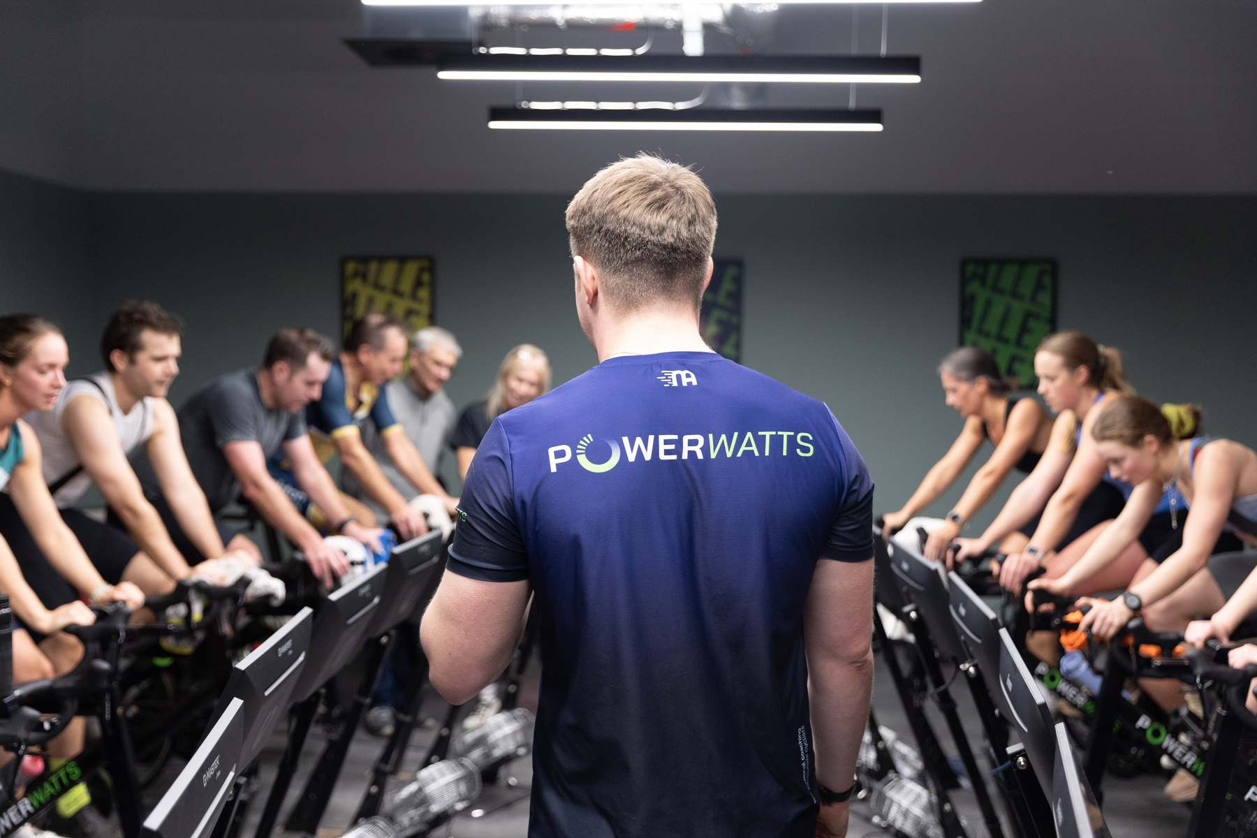 A coached session at PowerWatts Brighton, riders training together under studio lights